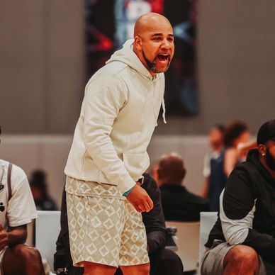 A basketball coach passionately directs his team during a game.