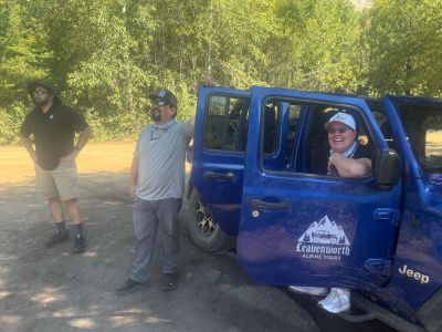 Guests standing beside a Jeep on a forest road during a private Chumstick Peak tour near Leavenworth.