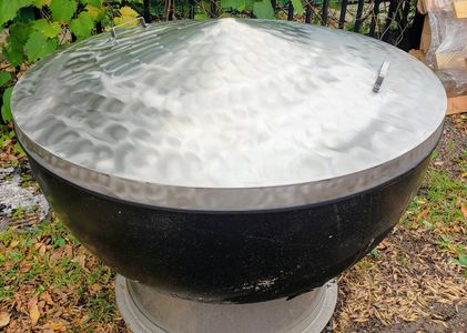 alt="large fire pit bowl with snuff cover."