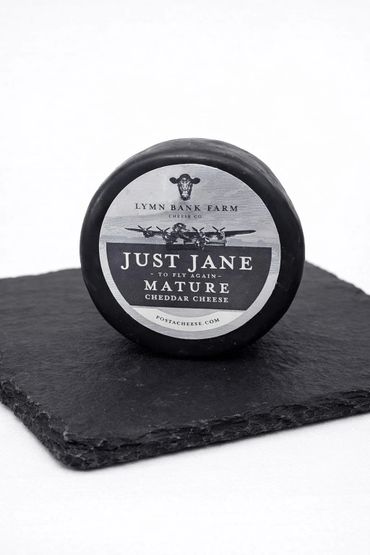 Round mature cheddar cheese from Lymn Bank Farm on a slate plate.