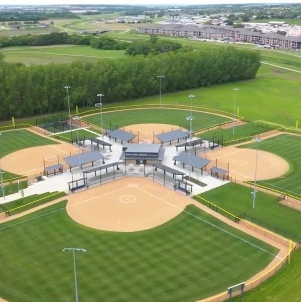 Aerial view of a multi-field baseball complex surrounded by greenery.