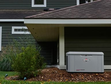 A Briggs and Stratton PowerProtect™ DX 26kW Standby Generator in front of a house.