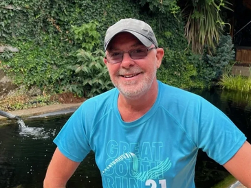 A man wearing blue tshirt posing for photo