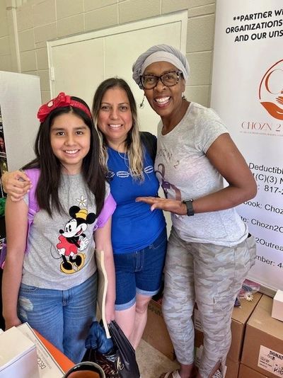 Three smiling women posing together indoors, showing warmth and friendship.