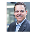 Smiling man in a suit with a professional background.