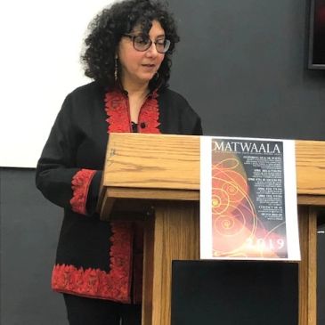 Woman speaking at a podium with a Matwaala 2019 poster.