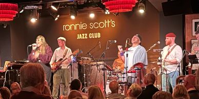 Live jazz performance at Ronnie Scott's Jazz Club with a lively band and engaged audience.