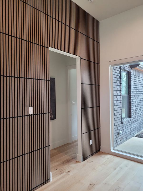 Modern room with vertical wooden slats and large window.
