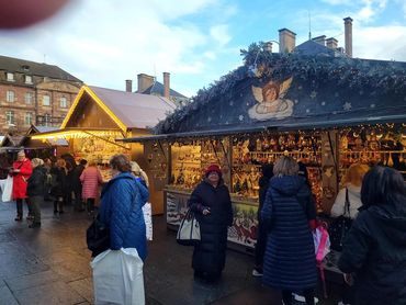 Strasbourg festive Christmas market with decorated stalls and bright lights.