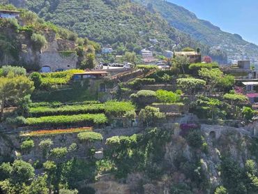 Terraced greenery and stone structures on a hillside in Ravello, Italy