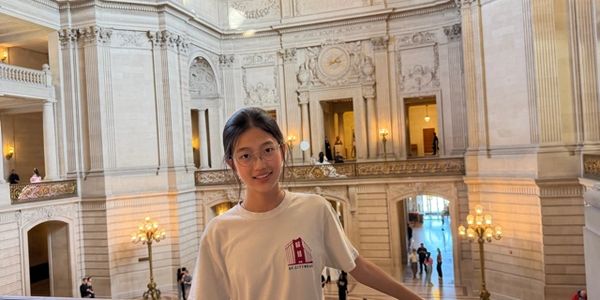 Young woman smiling inside an ornate building.