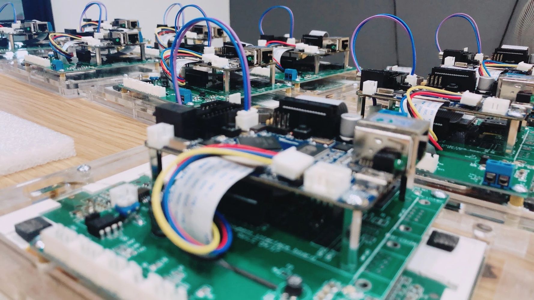 Close-up of multiple electronic circuit boards with connectors and wires on a table.