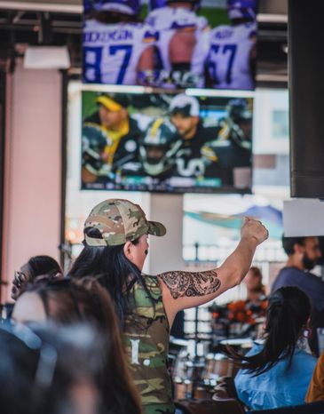 Person cheering on sports team at sports bar