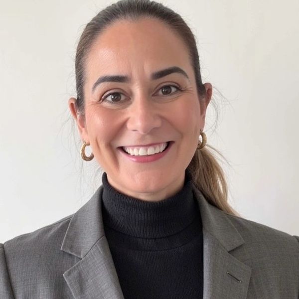Smiling woman in a gray blazer and black turtleneck.