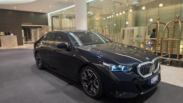 Black BMW sedan displayed indoors with modern lighting.