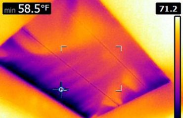 Infrared image showing cold air infiltration around an attic pull down staircase.