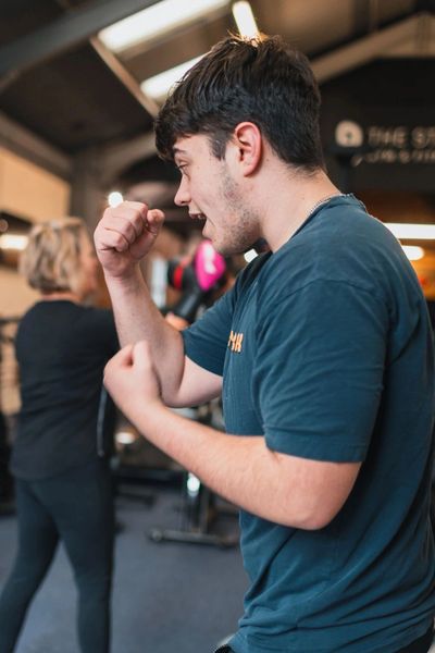 Man practicing boxing stance indoors.