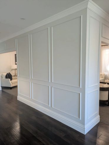Elegant white paneled wall with dark hardwood flooring in a modern home interior.