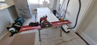 Milwaukee M18 Fuel circular saw setup on a work table in a room under renovation.