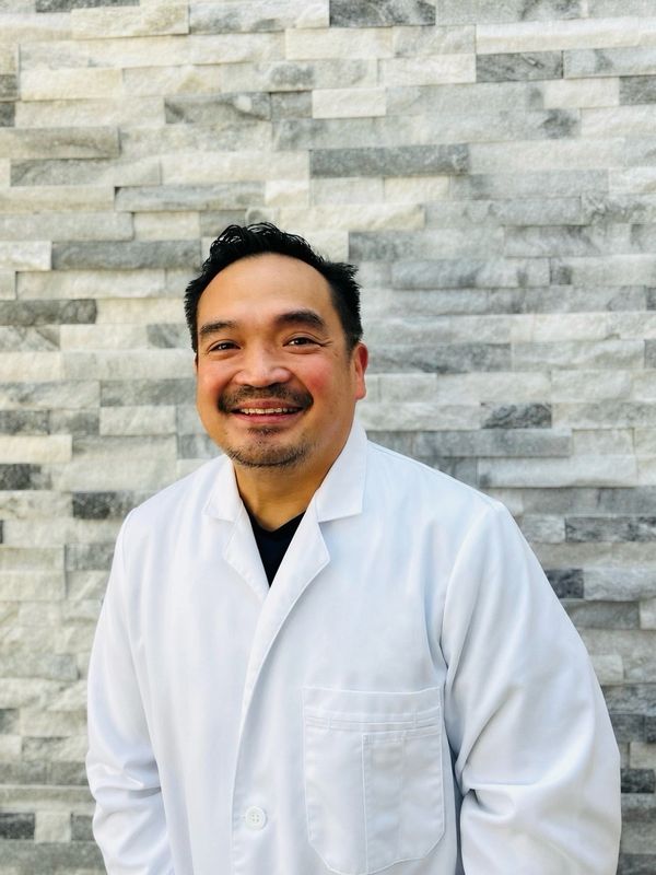 Smiling man in white lab coat.