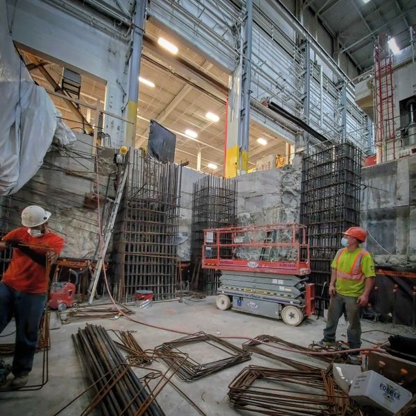 Construction workers working with rebars in an industrial manufacturing facility