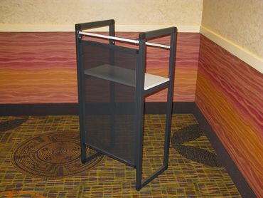 A modern black and white podium stands in a colorful room corner.