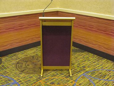 Empty podium with microphone in a corner of a conference room.
