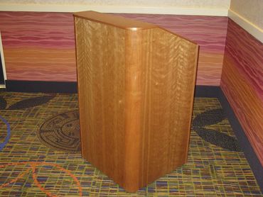 Wooden podium on patterned carpet with colorful wall background.
