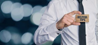 Person holding a card saying Helpful Tips.