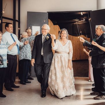 Bride & Groom exiting wedding venue to join their reception.