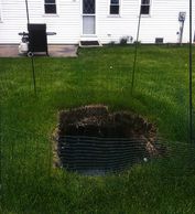 Sink hole in lawn due to corroded concrete tank that failed underground