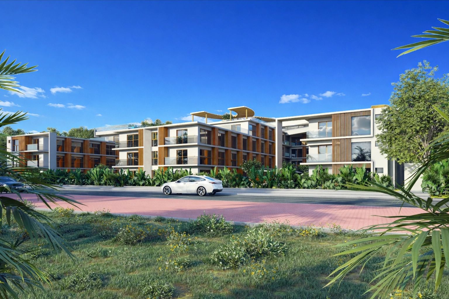 Modern three-story residential complex with greenery and a white car in front.