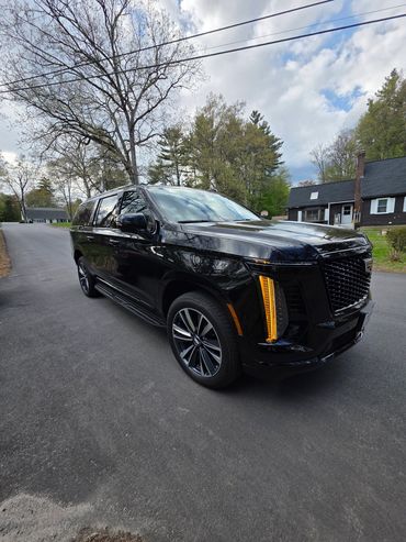 Black luxury SUV parked on a residential street.