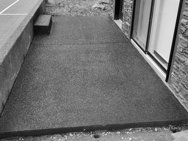 Exposed aggregate concrete patio with step, black proline stain