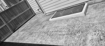 Concrete sidewalk and window well with rustic finish