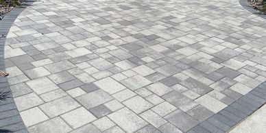 Curved pathway with gray and white interlocking pavers.
