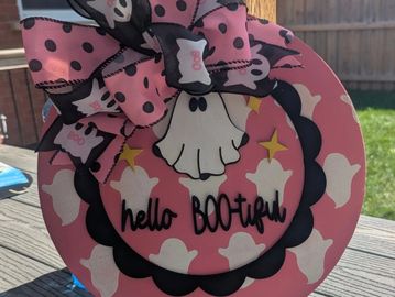 Decorative Halloween sign with ghosts and a bow saying 'hello BOOtiful'.