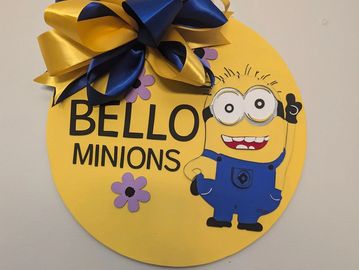 Decorative Minions-themed wall hanging with a bow and flowers.