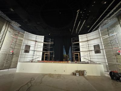 Empty stage under construction with scaffolding and tools.