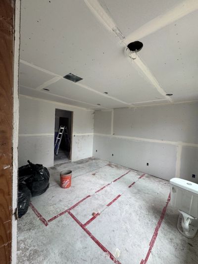 Room under construction with drywall and exposed closet ceiling.