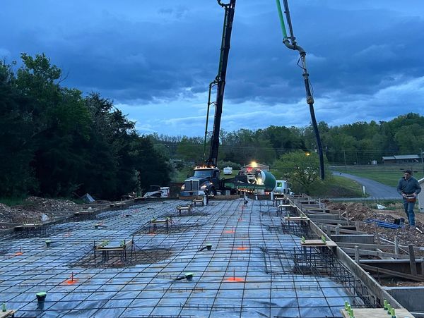 Concrete pouring at a construction site during early evening.