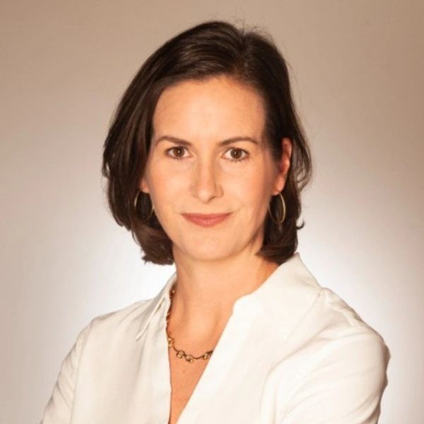 Headshot of a woman in her 50s with brown hair looking directly into the camera, smiling slightly.