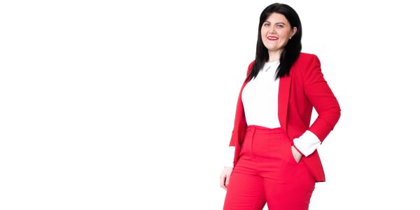 Woman in a red suit smiling.