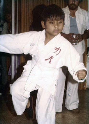 Ollie at 10 years old in a white karate uniform mid karate match.