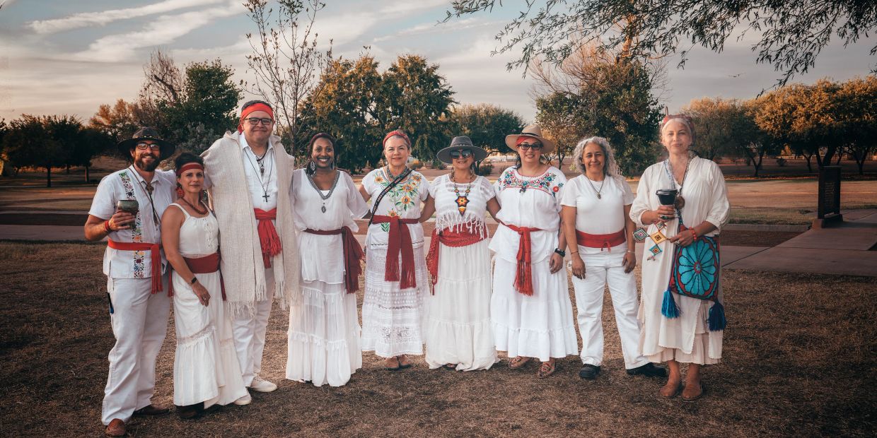 Group of people in white traditional clothing outdoors.