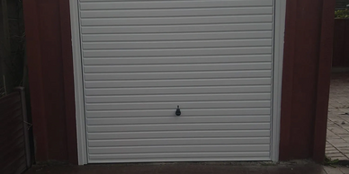 Closed white garage door with a handle in the center.