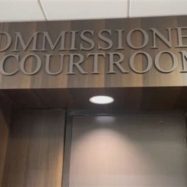 Partial sign of a court office with the words 'Commissioner Courtroom'.