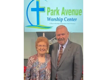 An elderly couple smiling inside Park Avenue Worship Center.