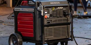 Honda EU7000is portable generator on pavement with power cable plugged in.