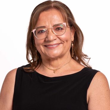 Smiling middle-aged woman wearing glasses and a black sleeveless top.